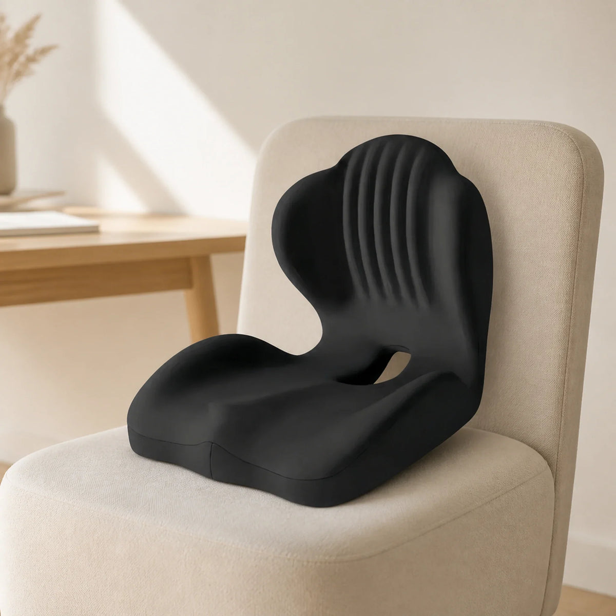 Black one-piece seat-and-back cushion on an oatmeal upholstered chair beside a light wood desk.